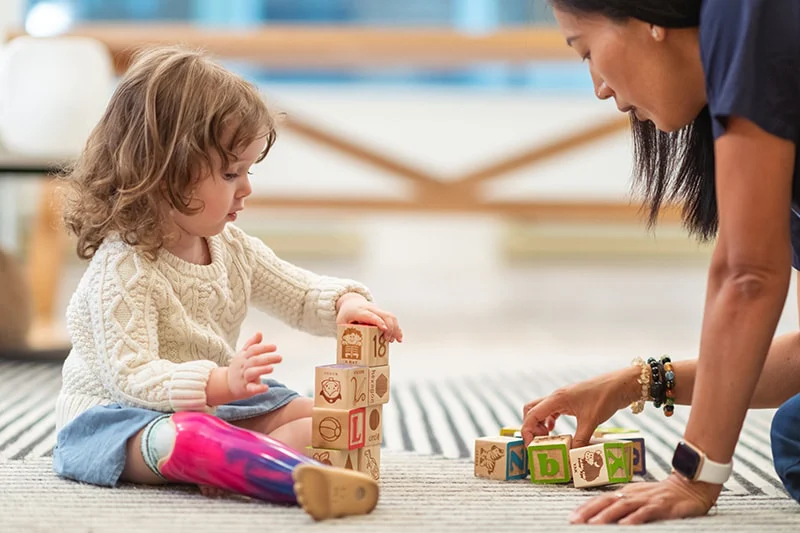A therapist playing on the floor with a child