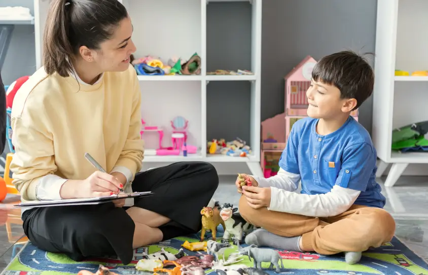 A therapist playing on the floor with a child